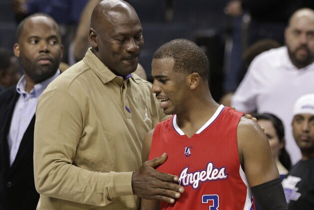 Charlotte Hornets owner Michael Jordan, left, talks with Los Angeles Clippers' Chris Paul, right, after an NBA basketball game in Charlotte, N.C., Monday, Nov. 24, 2014. The Clippers won 113-92. (AP Photo/Chuck Burton)