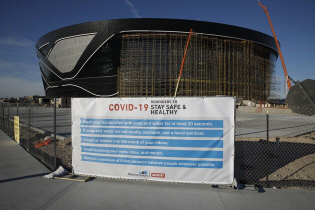 A sign gives guidelines for protection from COVID-19 as construction continues at Allegiant Stadium, future home of the Raiders NFL football team, during the coronavirus pandemic Tuesday, March 31, 2020, in Las Vegas. (AP Photo/John Locher)