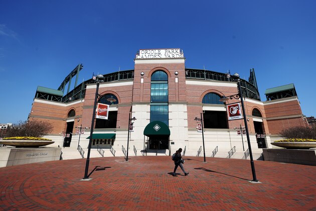 BALTIMORE, MARYLAND - MARCH 26: A woman walks past the home plate entrance of Oriole Park at Camden Yards on March 26, 2020 in Baltimore, Maryland. The Baltimore Orioles and New York Yankees Opening Day game scheduled for today, along with the entire MLB season, has been postponed due to the COVID-19 pandemic.  (Photo by Rob Carr/Getty Images)