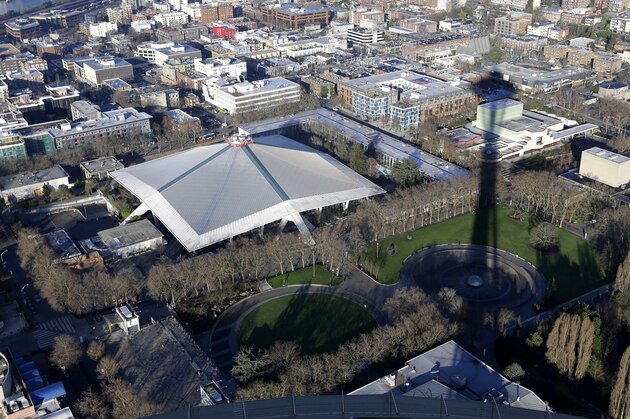 FILE - In this Jan. 29, 2015, file photo, KeyArena, which hosts sports and entertainment events, is seen from the air next to the shadow of the Space Needle in Seattle. Seattle Mayor Ed Murray announced Wednesday, June 7, 2017, that the city will enter into negotiations with the Oak View Group on a proposal for a privately-financed renovation of the city-owned KeyArena. Plans for the remodel would bring the building up to standards that could attract an NHL hockey or NBA basketball team once completed. (AP Photo/Ted S. Warren)