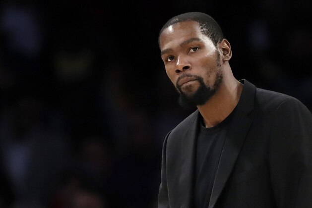 FILE- In this March 10, 2020, file photo, Brooklyn Nets' Kevin Durant watches during the second half of the team's NBA basketball game against the Los Angeles Lakers in Los Angeles. Durant is among the four Brooklyn Nets who have tested positive for the new coronavirus. (AP Photo/Marcio Jose Sanchez, file)