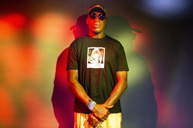 In this Monday, Sept. 9, 2019, photo, former NBA star Dennis Rodman poses wearing a T-shirt depicting himself in a wedding dress at a 1996 book promo event, in Los Angeles. The former NBA star, featured in a new ESPN documentary, weighs in on his personal brand, bisexual athletes, North Korea and Trump. Rodman's spectacular personal highs and very public lows are the subject of the new ESPN