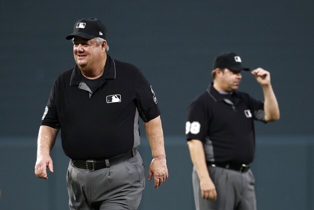 Umpire Joe West, left, walks past umpire Doug Eddings during a baseball game between the Baltimore Orioles and the Toronto Blue Jays, Monday, Aug. 27, 2018, in Baltimore. (AP Photo/Patrick Semansky)
