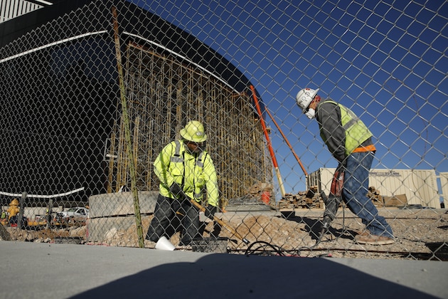 Workers dig as construction continues at Allegiant Stadium, future home of the Raiders NFL football team, during the coronavirus pandemic Tuesday, March 31, 2020, in Las Vegas. (AP Photo/John Locher)