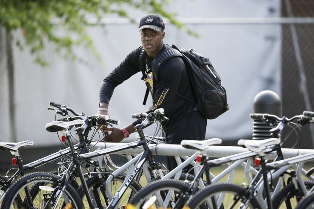 Minnesota Vikings quarterback Teddy Bridgewater arrives on his bike during NFL football training camp, Friday, July 25, 2014, in Mankato, Minn. (AP Photo/Charlie Neibergall)
