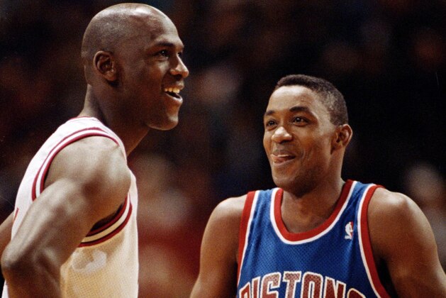 Chicago Bulls' Michael Jordan, left, and Isiah Thomas of the Detroit Pistons smile as they talk while waiting for the lights to brighten at Chicago Stadium before their game, Jan. 24, 1992.  The start of the game was delayed 30 minutes because of a broken fuse, and most of the first quarter was played in semi-darkness.  (AP Photo/Fred Jewell)