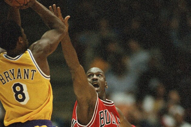Chicago Bulls Michael Jordan (23) reaches to defend against Los Angeles Lakers Kobe Bryant (8) during the second quarter action, Feb. 1, 1998 in Inglewood, California. Lakers routed the Bulls, 112-87. (AP Photo/Kevork Djansezian)