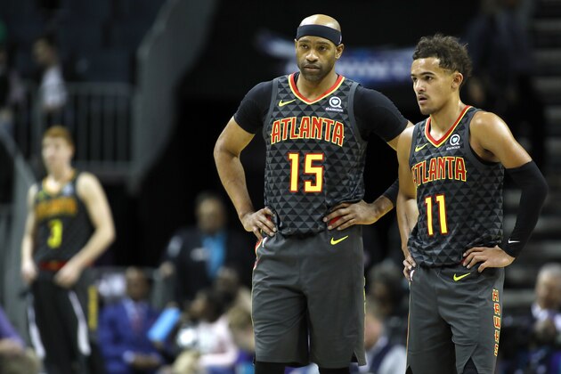 Atlanta Hawks' Vince Carter (15) huddles with teammate Trae Young (11) during the second half of an NBA basketball game against the Charlotte Hornets in Charlotte, N.C., Sunday, Dec. 8, 2019. The Hawks won 122-107. (AP Photo/Bob Leverone)
