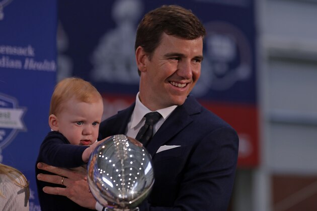 New York Giants NFL football quarterback Eli Manning with his son Charles after announcing his retirement on Friday, Jan. 24, 2020, in East Rutherford, N.J. (AP Photo/Adam Hunger)
