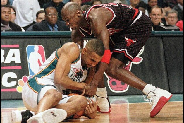AUBURN HILLS, UNITED STATES:  Grant Hill of the Detroit Pistons (L) and Michael Jordan of the Chicago Bulls (R) fight for a loose ball in the first quarter of their 13 April game at the Palace in Auburn Hills, Michigan. (Photo credit should read MATT CAMPBELL/AFP via Getty Images)
