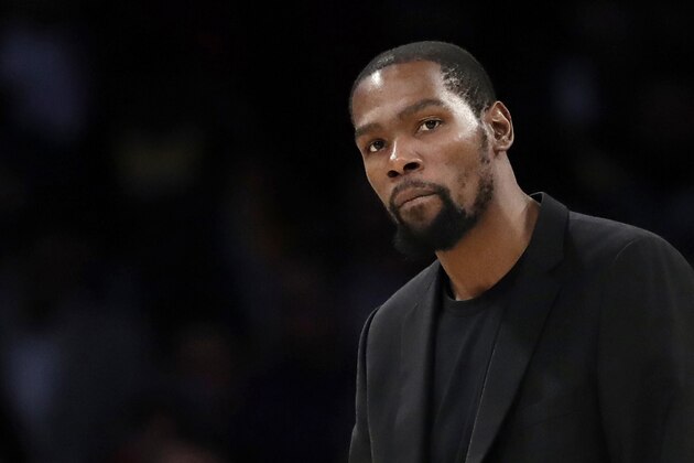 FILE- In this March 10, 2020, file photo, Brooklyn Nets' Kevin Durant watches during the second half of the team's NBA basketball game against the Los Angeles Lakers in Los Angeles. Durant is among the four Brooklyn Nets who have tested positive for the new coronavirus.  A backlash roiled across social media Wednesday, March 18, as several celebrities and professional athletes revealed that they had been tested for the coronavirus, even when they didnâ€™t have a fever or other tell-tale symptoms. (AP Photo/Marcio Jose Sanchez, file)