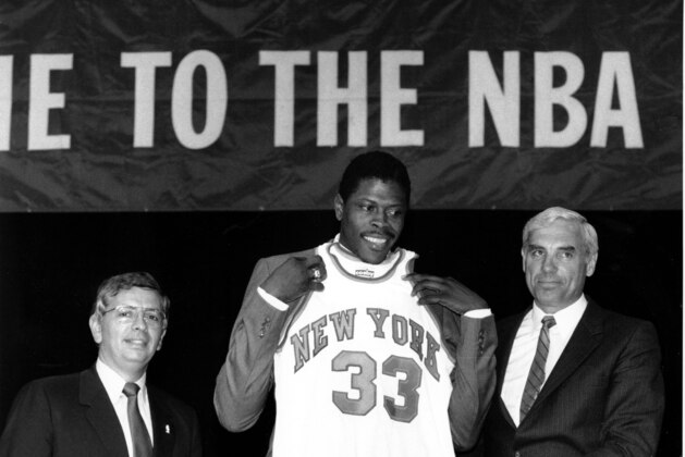 FILE - In this June 18, 1985, file photo, Patrick Ewing accepts his New York Knicks jersey from Dave DeBusschere, right, general manager of the Knicks, as NBA commissioner David Stern look on, at the NBA Draft in New York. The NBA draft lottery debuted 30 years ago. The 2015 NBA draft lottery will take place in New York on Tuesday, May 19, 2015. (AP Photo/Marty Lederhandler, File)