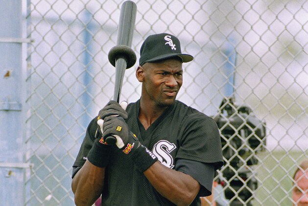 Michael Jordan swings a weighted bat while waiting for his turn in the batting cage during his first day of spring training with the Chicago White Sox, in Sarasota, FL., Feb. 2, 1994. (AP Photo/John Swart)