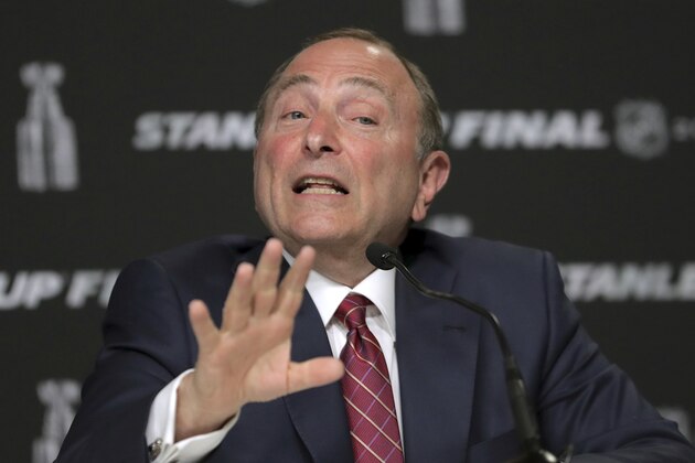 FILE - In this May 27, 2019, file photo, NHL Commissioner Gary Bettman speaks to the media before Game 1 of the NHL hockey Stanley Cup Final between the St. Louis Blues and the Boston Bruins in Boston. The most aggressive timetable, a person familiar with discussions told The Associated Press, would have players returning to their home rinks as early as May 15, followed by a training camp and possible exhibition games in June. Bettman emphasized no decisions have been made and cautioned government and medical officials will ultimately make the call on when sports can return. (AP Photo/Charles Krupa, File)