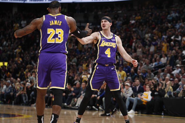 Los Angeles Lakers forward LeBron James, left, congratulates guard Alex Caruso after he scored a basket late in the second half of an NBA basketball game, Wednesday, Feb. 12, 2020, in Denver. The Lakers won 120-116 in overtime. (AP Photo/David Zalubowski)