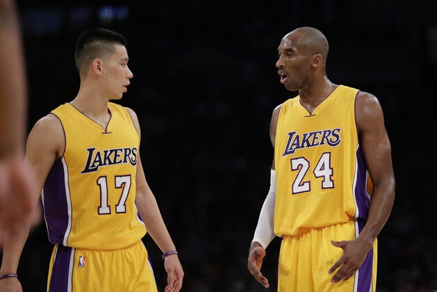 Los Angeles Lakers' Kobe Bryant, right, talks to Jeremy Lin during the first half of an NBA basketball game Tuesday, Dec. 9, 2014, in Los Angeles. (AP Photo/Jae C. Hong)