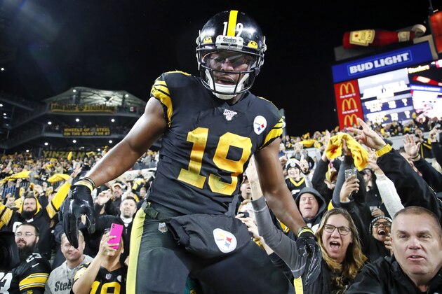 Pittsburgh Steelers wide receiver JuJu Smith-Schuster (19) climbs out down from the stands after celebrating his touchdown with fans during the second half of an NFL football game against the Miami Dolphins in Pittsburgh, Monday, Oct. 28, 2019. (AP Photo/Don Wright)