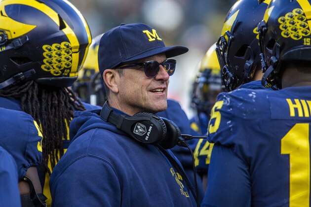 Michigan head coach Jim Harbaugh huddles with his players on the field during a time out in the fourth quarter of an NCAA college football game against Michigan State in Ann Arbor, Mich., Saturday, Nov. 16, 2019. Michigan won 44-10. (AP Photo/Tony Ding) Michigan head coach Jim Harbaugh huddles with his players on the field during a time out in the fourth quarter of an NCAA college football game against Michigan State in Ann Arbor, Mich., Saturday, Nov. 16, 2019. Michigan won 44-10. (AP Photo/Tony Ding)