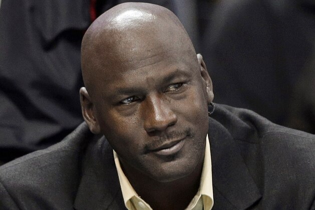 FILE - In this April 16, 2014, file photo, Charlotte Bobcats owner Michael Jordan watches an NBA basketball game between the Bobcats and the Chicago Bulls in Charlotte, N.C. The six-time NBA champion is scheduled to appear Tuesday, Aug. 11, 2015, in federal court in Chicago for the start of a civil trial and will later testify on the unauthorized use of his identity. A court already ruled a grocery-story chain used his identity without permission in a magazine ad and so the unresolved legal issue is damages. (AP Photo/Chuck Burton, File)