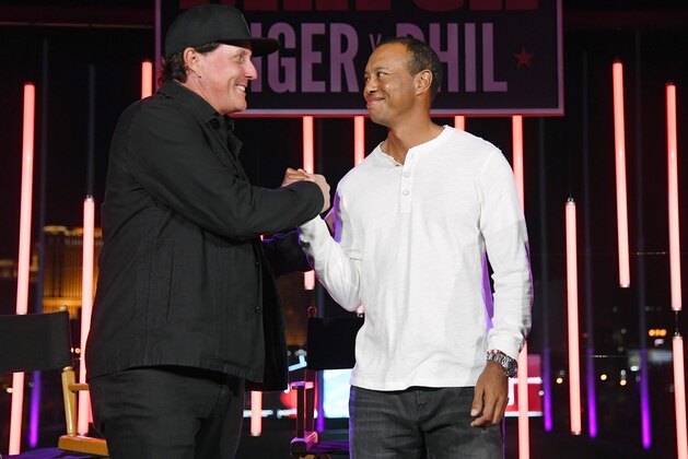 LAS VEGAS, NEVADA - NOVEMBER 23:  Phil Mickelson (L) and Tiger Woods greet each other at The Match: Tiger vs Phil VIP after party at Topgolf Las Vegas on November 23, 2018 in Las Vegas, Nevada. (Photo by Ethan Miller/Getty Images for The Match)