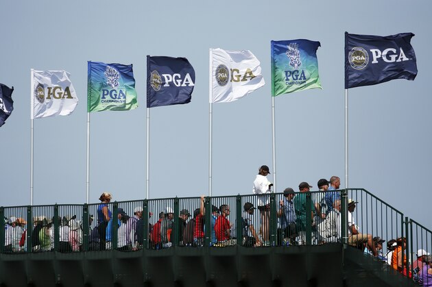 The flags are blowing as the wind picks up on the grandstands on the 12th hole during the first round of the PGA Championship golf tournament Thursday, Aug. 13, 2015, at Whistling Straits in Haven, Wis. (AP Photo/Julio Cortez)
