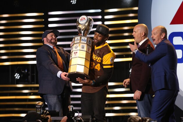 IMAGE DISTRIBUTED FOR EA SPORTS - Kansas City Chiefs safety Eric Berry is crowned EA SPORTS Madden Bowl XXII champion by NFL Network's Scott Cole, left,  and Adam Rank and EA's Peter Moore, right, Thursday, Feb. 4, 2016, in San Francisco. (Donald Traill/AP Images for EA SPORTS)