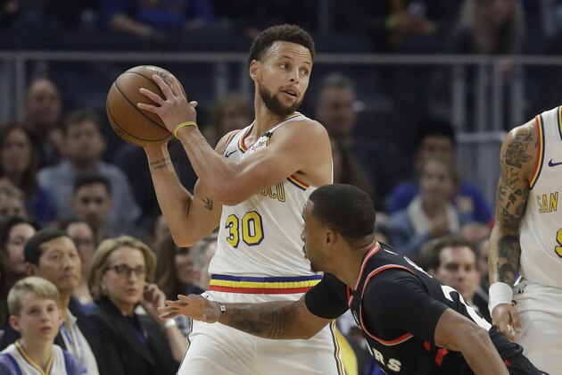 Golden State Warriors guard Stephen Curry (30) looks to pass over Toronto Raptors guard Norman Powell during the first half of an NBA basketball game in San Francisco, Thursday, March 5, 2020. (AP Photo/Jeff Chiu)