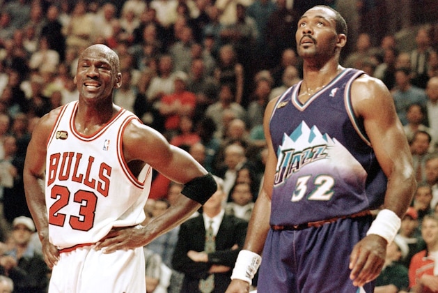 Michael Jordan (L) of the Chicago Bulls smiles while standing next to Karl Malone of the Utah Jazz 07 June in the first half of game three of the NBA Finals at the United Center in Chicago, IL. The seven game series is tied at 1-1. AFP PHOTO Jeff HAYNES (Photo by JEFF HAYNES / AFP) (Photo by JEFF HAYNES/AFP via Getty Images) Michael Jordan (L) of the Chicago Bulls smiles while standing next to Karl Malone of the Utah Jazz 07 June in the first half of game three of the NBA Finals at the United Center in Chicago, IL. The seven game series is tied at 1-1. AFP PHOTO Jeff HAYNES (Photo by JEFF HAYNES / AFP) (Photo by JEFF HAYNES/AFP via Getty Images)