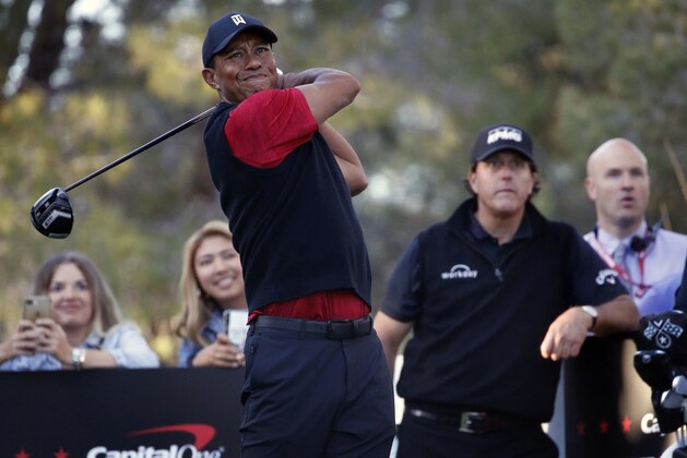 Tiger Woods hits off the 16th tee as Phil Mickelson watches during a golf match at Shadow Creek golf course, Friday, Nov. 23, 2018, in Las Vegas. (AP Photo/John Locher)
