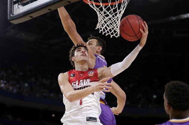 LaMelo Ball of the Illawarra Hawks, left, lays up around Andrew Bogut of the Sydney Kings during their game in the Australian Basketball League in Sydney, Sunday, Nov. 17, 2019. (AP Photo/Rick Rycroft)