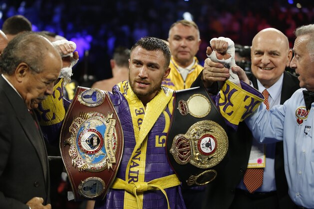 Vasiliy Lomachenko celebrates defending his WBA/WBO lightweight titles after knocking out Anthony Crolla in Los Angeles Friday, April 12, 2019. (AP Photo/Damian Dovarganes)