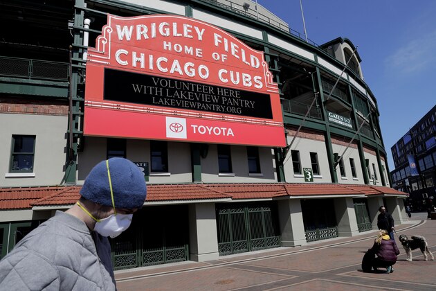 FILE - In this April 16, 2020, file photo, Wrigley Field's marquee displays Lakeview Pantry volunteer information in Chicago. With no games being played, recent sports headlines have centered around hopes and dreams â€” namely, the uncharted path leagues and teams must navigate to return to competition in the wake of the pandemic.  (AP Photo/Nam Y. Huh, File)