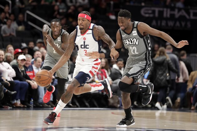 Washington Wizards' Bradley Beal (3) moves the ball as Brooklyn Nets' Taurean Prince (2) and Caris LeVert, right, defend during the first half of an NBA basketball game Wednesday, Feb. 26, 2020, in Washington. (AP Photo/Luis M. Alvarez)