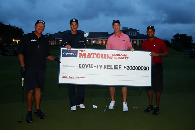 HOBE SOUND, FLORIDA - MAY 24: Tiger Woods and former NFL player Peyton Manning celebrate defeating Phil Mickelson and NFL player Tom Brady of the Tampa Bay Buccaneers on the 18th green during The Match: Champions For Charity at Medalist Golf Club on May 24, 2020 in Hobe Sound, Florida. (Photo by Mike Ehrmann/Getty Images for The Match)