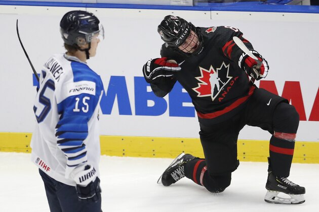 Finland's Lenni Killinen, left, skates past as Canada's Jamie Drysdale, right, celebrates after scoring his sides third goal during the U20 Ice Hockey Worlds semifinal match between Finland and Canada in Ostrava, Czech Republic, Saturday, Jan. 4, 2020. (AP Photo/Petr David Josek)