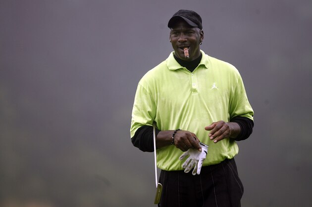 Former NBA basketball player Michael Jordan looks on while smoking a cigar during during the Golf Digest U.S. Open Challenge on Bethpage State Park's Black Course, Friday, June 12, 2009, in Farmingdale, N.Y. (AP Photo/Jason DeCrow)
