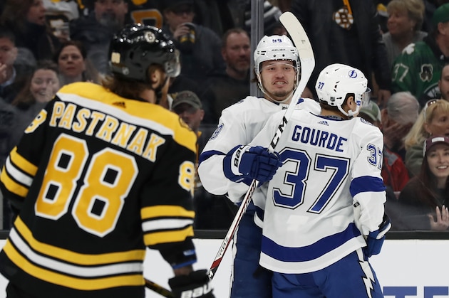 Tampa Bay Lightning's Mikhail Sergachev celebrates his shorthanded goal with teammate Yanni Gourde (37) as Boston Bruins' David Pastrnak skates away during the first period of an NHL hockey game Saturday, March 7, 2020, in Boston. (AP Photo/Winslow Townson)