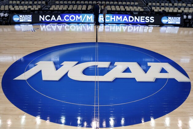 FILE - In this March 18, 2015, file photo, the NCAA logo is displayed at center court as work continues at The Consol Energy Center in Pittsburgh, for the NCAA college basketball tournament. NCAA President Mark Emmert says NCAA Division I basketball tournament games will be played without fans in the arenas because of concerns about the spread of coronavirus. (AP Photo/Keith Srakocic, File)