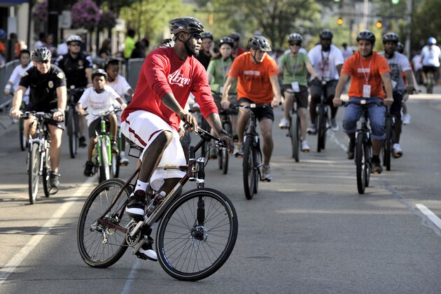 AKRON, OH - AUGUST 07:  LeBron James riding  a bike through the streets of Akron during his