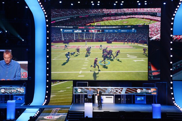 NFL Hall of Fame quarterback Joe Montana (L) plays the new EA Sports Madden 13 game as head of EA Sports Andrew Wilson (R) looks on after announcing all-new Kinect voice functionality for the new EA Sports games at the Microsoft Xbox E3 2012 media briefing in Los Angeles on June 4, 2012. The Electronic Entertainment Expo (E3), the video game industry's biggest event, runs from June 5-7.    AFP PHOTO/ROBYN BECK        (Photo credit should read ROBYN BECK/AFP/GettyImages)