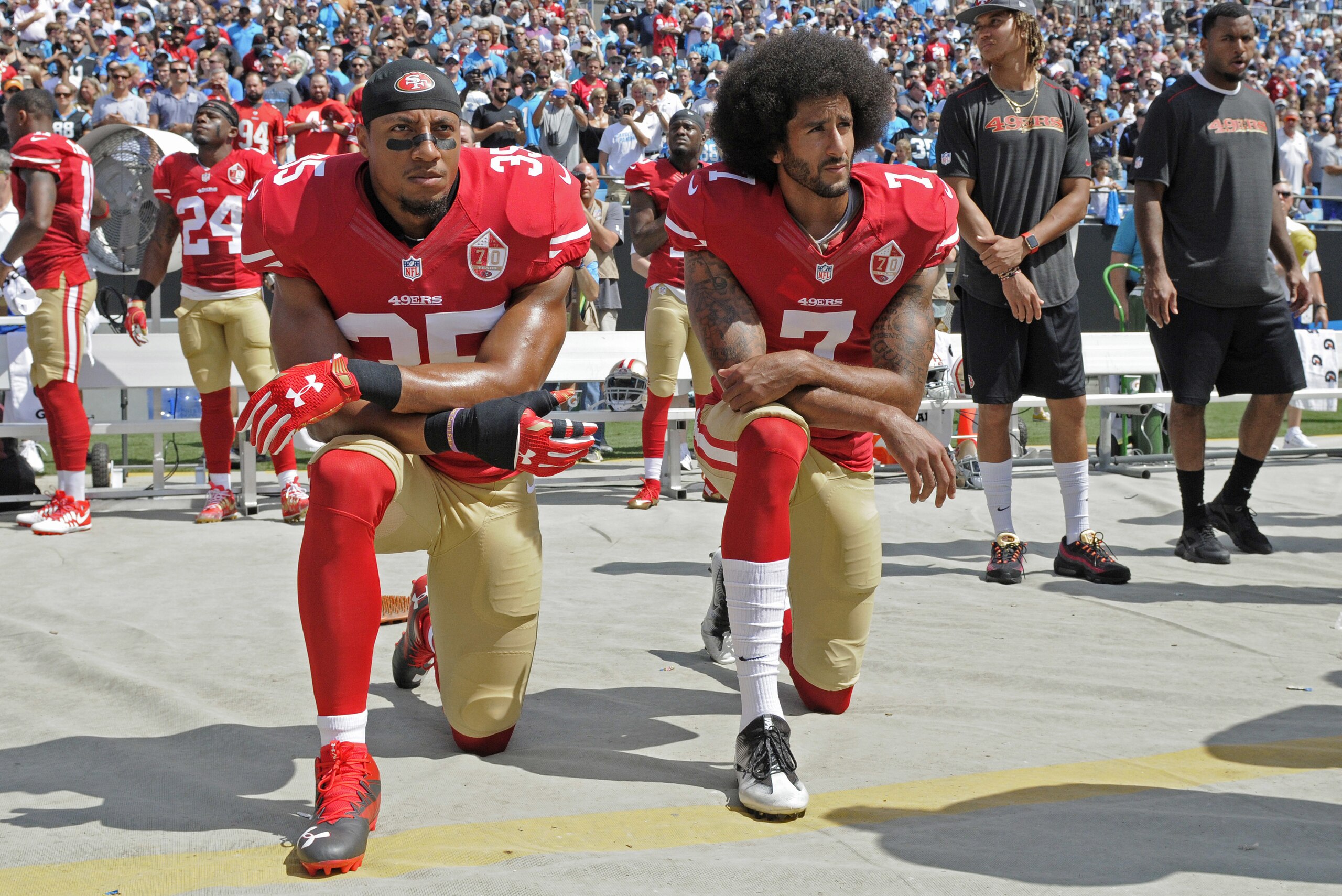 FILE - In this Sept. 18, 2016, file photo, San Francisco 49ers' Colin Kaepernick (7) and Eric Reid (35) kneel during the national anthem before an NFL football game against the Carolina Panthers, in Charlotte, N.C. Colin Kaepernick and Eric Reid have reached settlements on their collusion lawsuits against the NFL, the league said Friday, Feb. 19, 2019. (AP Photo/Mike McCarn, File)