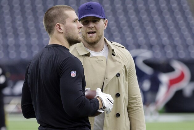 Houston Texans defensive end J.J. Watt, right, talks with his brother, Pittsburgh Steelers outside linebacker T.J. Watt, before an NFL football game Monday, Dec. 25, 2017, in Houston. (AP Photo/Michael Wyke)