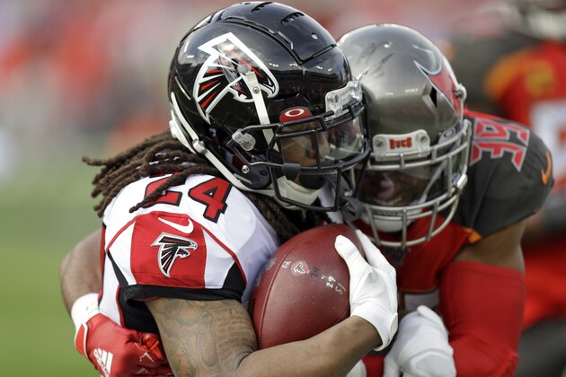 Atlanta Falcons running back Devonta Freeman (24) is stopped by Tampa Bay Buccaneers strong safety Andrew Adams (39) on a run during the first half of an NFL football game Sunday, Dec. 29, 2019, in Tampa, Fla. (AP Photo/Chris O'Meara)