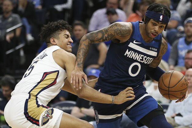 Minnesota Timberwolves' D'Angelo Russell, right, handles the ball around the defense of New Orleans Pelicans' Frank Jackson in the first half of an NBA basketball game Sunday, March 8, 2020, in Minneapolis. (AP Photo/Stacy Bengs)