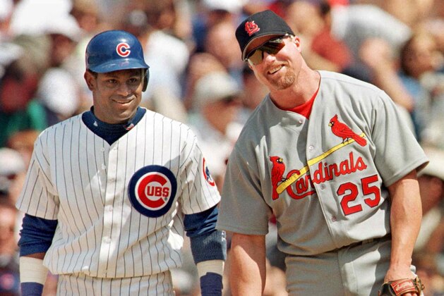 The Chicago Cubs' Sammy Sosa stands with St. Louis Cardinal's first baseman Mark McGwire between pitches after Sosa singled in the second inning 28 May, 1999, at Wrigley Field in Chicago, Illinois. It was the first time the pair had played each other since last year's home run race. The Cubs won 6-3 with help from a home run from Sosa.    AFP PHOTO/John ZICH (Photo by JOHN ZICH / AFP)        (Photo credit should read JOHN ZICH/AFP via Getty Images)