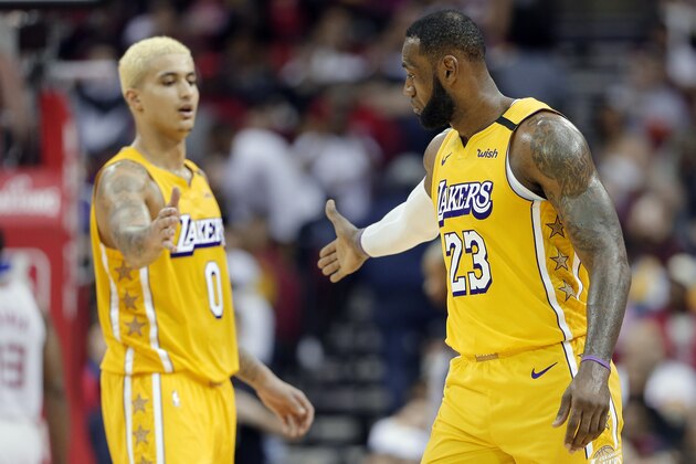Los Angeles Lakers forwards Kyle Kuzma (0) and LeBron James (23) celebrate the team's impending win over the Houston Rockets, in the final minute of an NBA basketball game Saturday, Jan. 18, 2020, in Houston. (AP Photo/Michael Wyke)