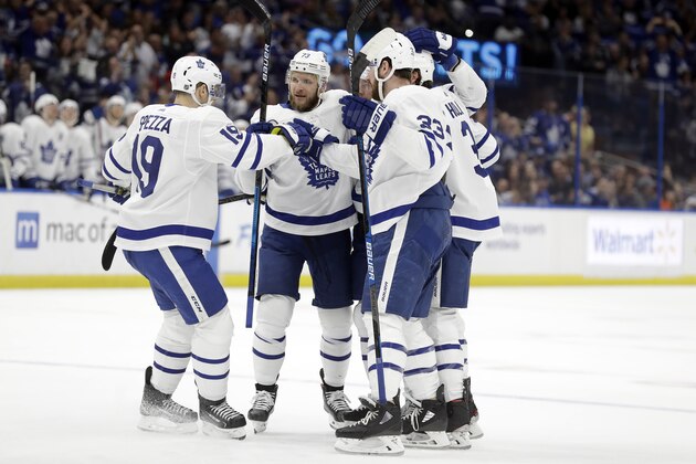 Toronto Maple Leafs players, including center Jason Spezza (19), center Frederik Gauthier (33), and left wing Kyle Clifford (73) celebrate a goal by Jake Muzzin during the first period of an NHL hockey game against the Tampa Bay Lightning Tuesday, Feb. 25, 2020, in Tampa, Fla. (AP Photo/Chris O'Meara)