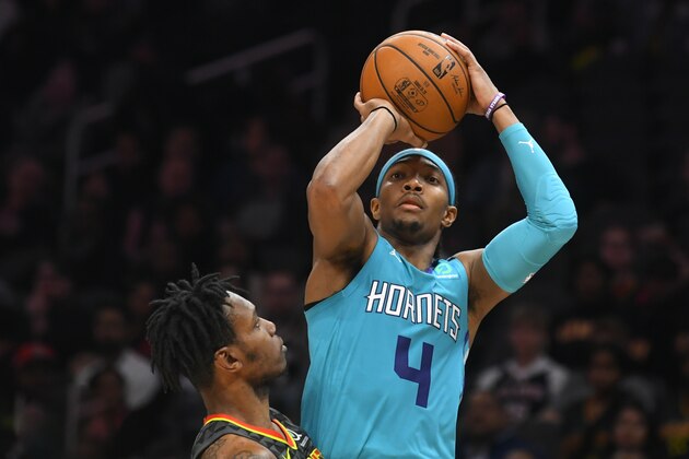 Charlotte Hornets guard Devonte' Graham (4) shoots as Atlanta Hawks guard Treveon Graham defends during overtime in an NBA basketball game Monday, March 9, 2020, in Atlanta. (AP Photo/John Amis)