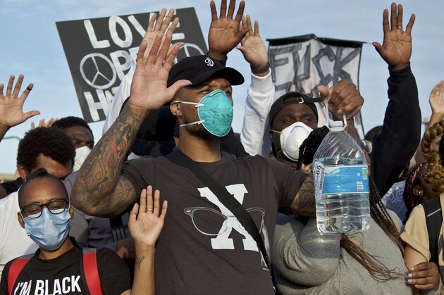 Portland Trail Blazers' Damian Lillard, center, joins other demonstrators in Portland, Ore., during a protest against police brutality and racism, sparked by the death of George Floyd, who died May 25 after being restrained by police in Minneapolis. (AP Photo/Craig Mitchelldyer)