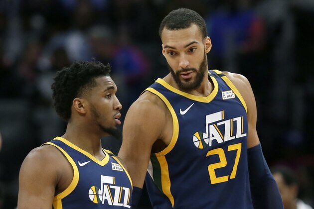 FILE - In this Saturday, March 7, 2020, file photo, Utah Jazz center Rudy Gobert (27) talks with guard Donovan Mitchell, left, during the second half of an NBA basketball game against the Detroit Pistons, in Detroit. Both players have tested positive for the coronavirus.  Gobert's test result forced the NBA to suspend the season. (AP Photo/Duane Burleson, File)